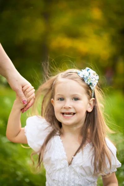 Маленькая девочка в поле с белыми цветами — стоковое фото