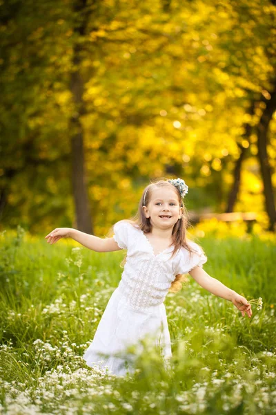 Μικρό κορίτσι σε ένα πεδίο με λευκά λουλούδια — Φωτογραφία Αρχείου