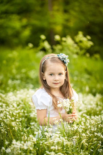 Menina em um campo com flores brancas — Fotografia de Stock