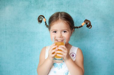 Bardak suyu ile komik pigtails ile gülümseyen kız