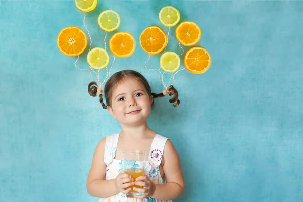 Smiling girl drinks fresh orange juice