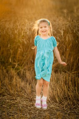 Mutlu kız sıcak ve güneşli yaz akşam buğday alanında