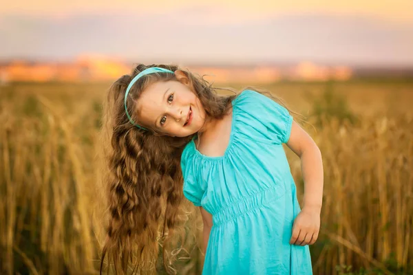 Happy girl in wheat field on warm and sunny summer evening — Stock Photo, Image