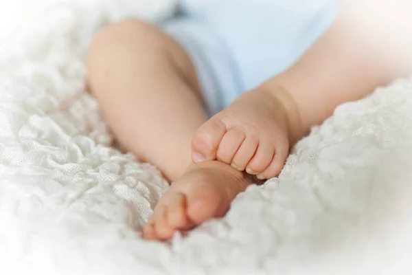 Roztomilé dětské nohy na bílou přikrývkou — Stock fotografie