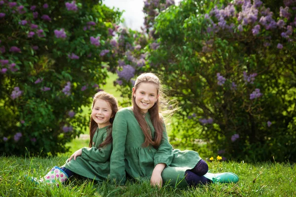 Duas Irmãs Vestido Linho Verde Divertir Parque Com Lilases Floridos — Fotografia de Stock