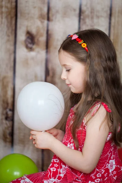 Sorrindo Menina Vestido Vermelho Fundo Madeira Brincando Com Balões — Fotografia de Stock