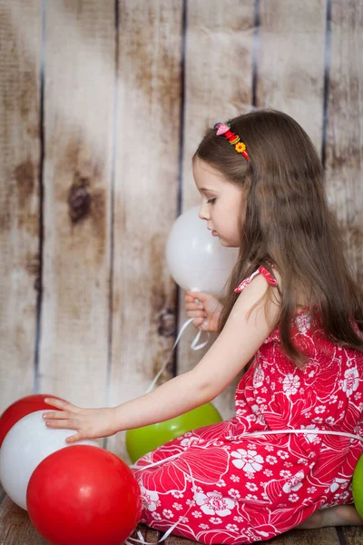 Mosolygó Fiatal Lány Egy Piros Ruha Háttér Játszik Léggömbök — Stock Fotó