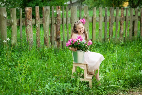 Krásná Malá Brunetka Dívka Kovovým Kbelíkem Velkou Pivoňkou Kytice Sedí — Stock fotografie