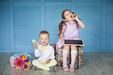 Büyük zencefilli kalemler ve bir buket sonbahar çiçeğiyle mutlu anaokulu çocukları. Okula geri dön.