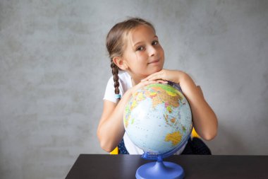 Küresel bir üniforma içinde örgülü saçları olan mutlu bir okul kızının portresi. Okula dönelim. Evden uzakta öğrenme, evde kal.