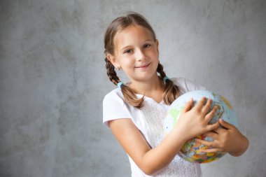 Küresel bir üniforma içinde örgülü saçları olan mutlu bir okul kızının portresi. Okula dönelim. Evden uzakta öğrenme, evde kal.