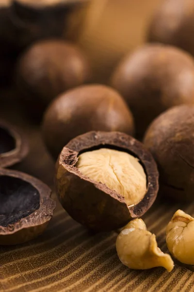 Nueces de macadamia sobre fondo de madera — Foto de Stock