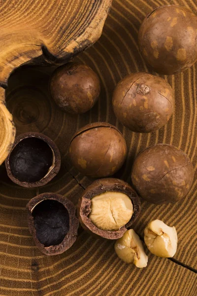 Macadamia ořechy na dřevěné pozadí — Stock fotografie