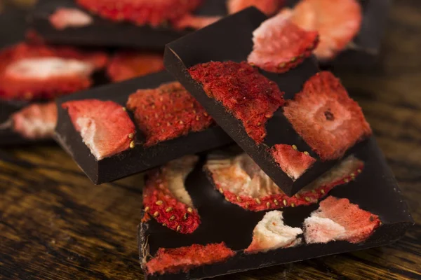 Pile de tranches de chocolat avec fraise sur fond en bois — Photo