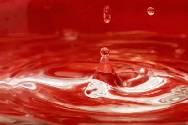 Vízcsepp Piros Háttér — Stock Fotó