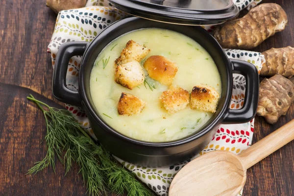 Creamy Jerusalem artichoke soup on wooden background — Stock Photo, Image