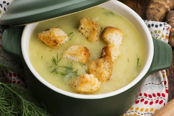 Creamy Jerusalem artichoke soup on wooden background — Stock Photo, Image