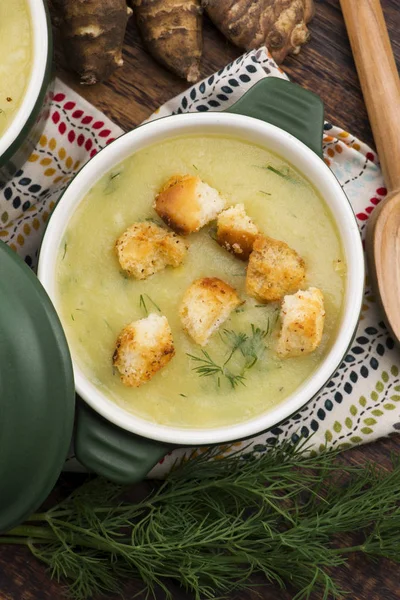 Creamy Jerusalem artichoke soup on wooden background — Stock Photo, Image