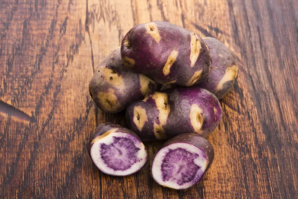 White - violet potato on wooden background. Organic plant — Stock Photo, Image