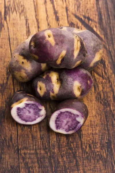Белый - фиолетовый картофель на деревянном фоне. Органические растения — стоковое фото