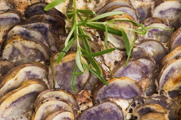 Violet potato gratin with cream and rosemary — Stock Photo, Image