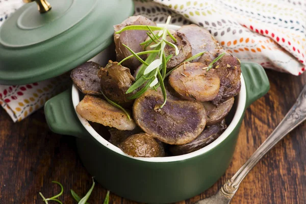 Fatias de batata violeta despedido com ervas, vista de perto — Fotografia de Stock