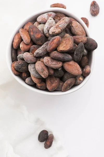 Bowl of cacao beans on a white background — Stock Photo, Image