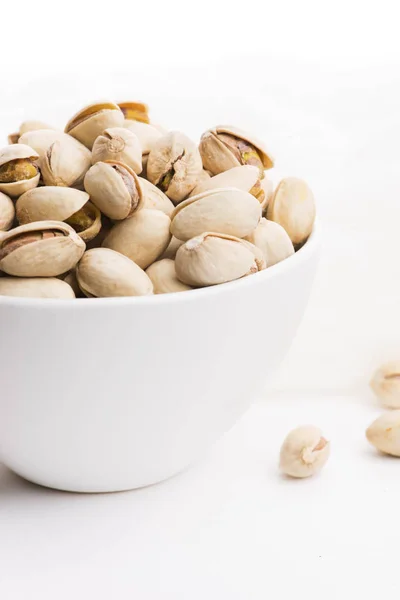 Bowl of roasted pistachios on a white background — Stock Photo, Image