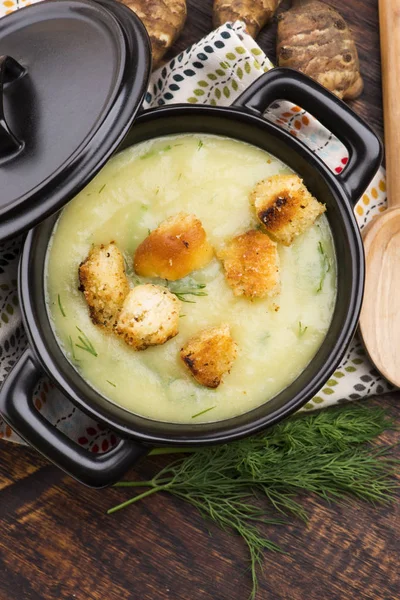 Sopa de alcachofra de Jerusalém cremosa em fundo de madeira — Fotografia de Stock