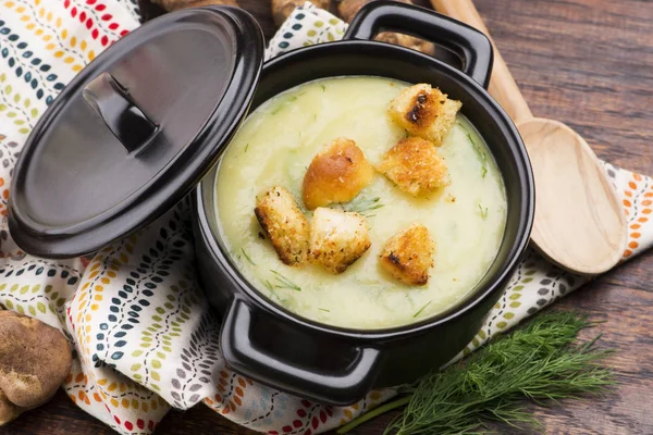 Creamy Jerusalem artichoke soup on wooden background — Stock Photo, Image