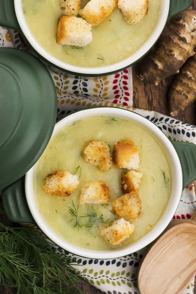 Creamy Jerusalem artichoke soup on wooden background — Stock Photo, Image