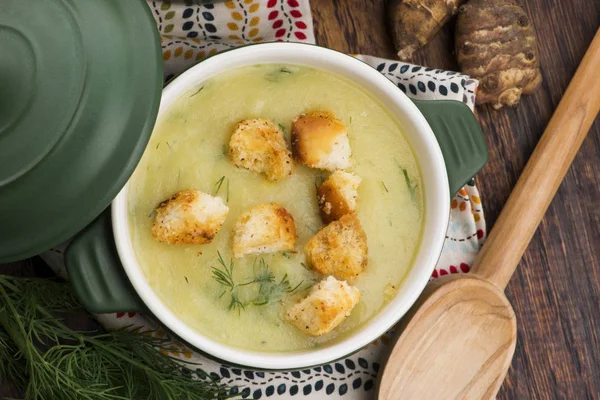 Creamy Jerusalem artichoke soup on wooden background — Stock Photo, Image