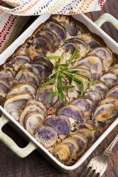 Violet potato gratin with cream and rosemary — Stockfoto