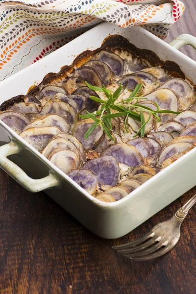 Gratinado de batata violeta com creme e alecrim — Fotografia de Stock