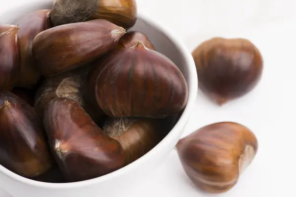 Bowl of chestnuts on a white background Stock Picture