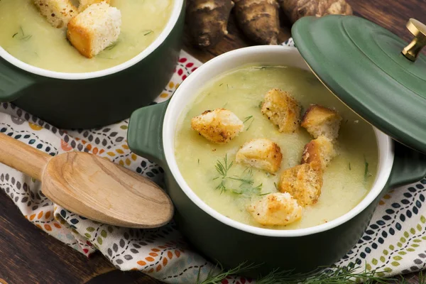 Creamy Jerusalem artichoke soup on wooden background — Stock Photo, Image