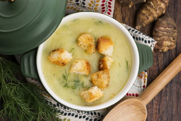 Creamy Jerusalem artichoke soup on wooden background — Stock Photo, Image