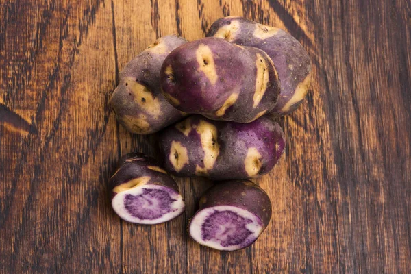 White - violet potato on wooden background. Organic plant — Stock Photo, Image