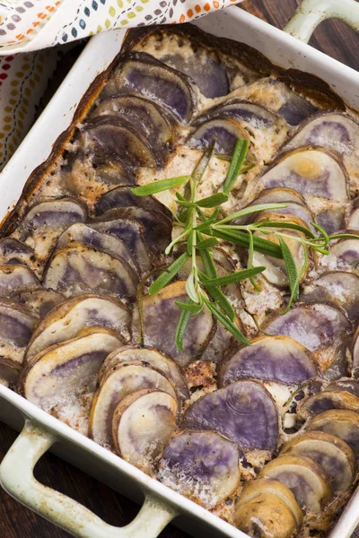 Violet potato gratin with cream and rosemary — Stockfoto