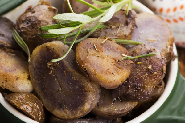 Fatias de batata violeta despedido com ervas, vista de perto — Fotografia de Stock