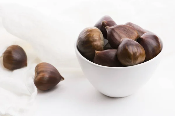 Bowl of chestnuts on a white background — Stock Photo, Image