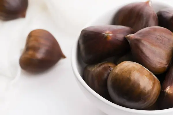 Bowl of chestnuts on a white background Stock Photo