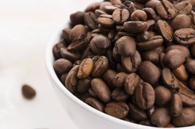 Beyaz arka planda bir kase kahve çekirdeği.