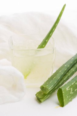Taze aloe vera suyu ve yapraklı cam eşyalar.