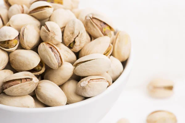 Bowl of roasted pistachios on a white background — Stock Photo, Image