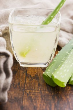 Taze aloe vera suyu ve yapraklı cam eşyalar.