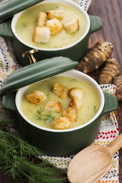 Creamy Jerusalem artichoke soup on wooden background — Stock Photo, Image