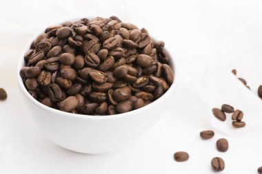 Beyaz arka planda bir kase kahve çekirdeği.