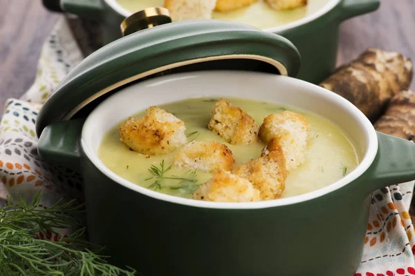 Creamy Jerusalem artichoke soup on wooden background — Stock Photo, Image