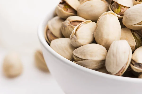 Bowl of roasted pistachios on a white background — Stock Photo, Image